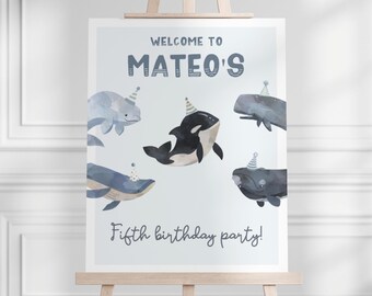 May include: A blue and white welcome sign for Mateo's fifth birthday party. The sign features a whale, a dolphin, and an orca wearing party hats.