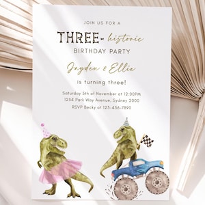 May include: A birthday party invitation with a green dinosaur wearing a pink tutu and a blue dinosaur driving a monster truck. The invitation reads "Join us for a Three-historic Birthday Party Jayden & Ellie is turning three! Saturday 5th of November at 12:00PM 1234 Park Way Avenue, Sydney 2000 RSVP Becky at 123-456-7890"