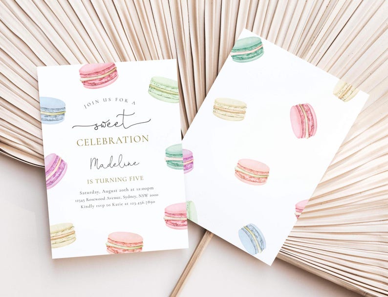 May include: A white invitation card with a gold border and text that reads "Join us for a sweet celebration Madeline is turning five". The card is decorated with watercolor illustrations of colorful macarons.