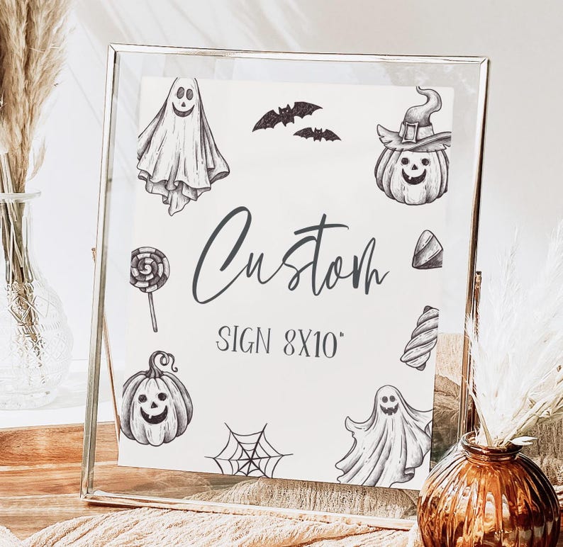 May include: A white sign with black Halloween-themed illustrations, including ghosts, pumpkins, bats, and candy. The sign reads "Custom Sign 8x10".