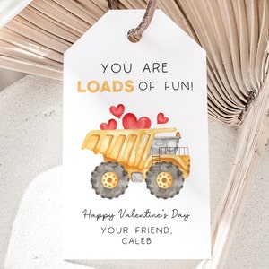 May include: A white card with a yellow dump truck carrying red hearts. The card says "You are loads of fun!" and "Happy Valentine's Day Your Friend, Caleb".