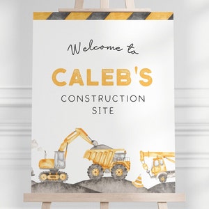 Op de afbeelding: Welkom bij Caleb's Construction Site bord met gele en zwarte strepen bovenaan. Het bord toont een gele graafmachine, een kiepwagen en een kraan op een grijze achtergrond.