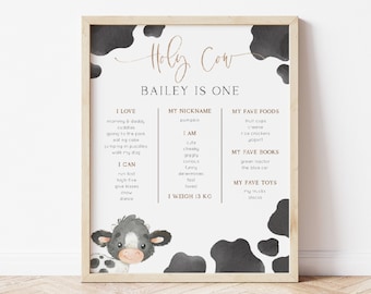 May include: A printable chart with a black and white cow pattern. The chart is titled "Holy Cow Bailey is One". It lists things the child loves, can do, their nickname, favorite foods, books, and toys. The child weighs 13 kg.