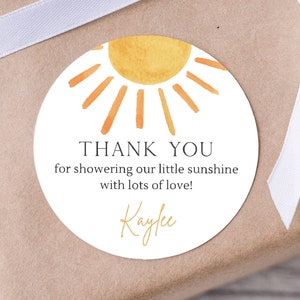 May include: Round white thank you tag with a watercolor sun illustration. The text reads "Thank you for showering our little sunshine with lots of love! Kaylee"