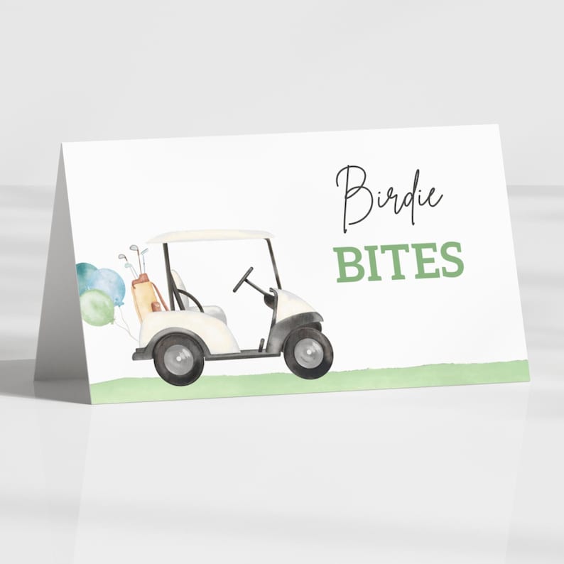 May include: A white card featuring a watercolour illustration of a golf cart, golf clubs, and balloons. The text "Birdie BITES" is written in black and green. The card is folded and stands upright.