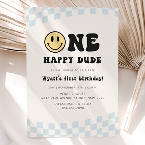 May include: A white and blue checkered background with a yellow smiley face and black text that reads "One Happy Dude". The text below reads "Please join us to celebrate Wyatt's first birthday! Sat | November 5th | 12 PM Wyatt's House 12345 Park Avenue. Sydney, NSW 2000 Please RSVP to Becky 123-456-7890".