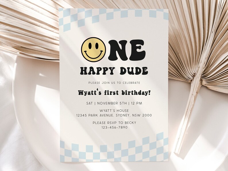 May include: A white and blue checkered background with a yellow smiley face and black text that reads "One Happy Dude". The text below reads "Please join us to celebrate Wyatt's first birthday! Sat | November 5th | 12 PM Wyatt's House 12345 Park Avenue. Sydney, NSW 2000 Please RSVP to Becky 123-456-7890".