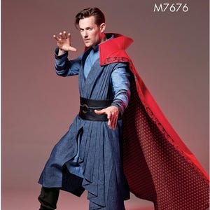 May include: A McCall's Costumes pattern for a Doctor Strange costume. The costume includes a blue tunic, a red cape with a patterned lining, and a black belt. The model is wearing black boots. The pattern number is M7676.