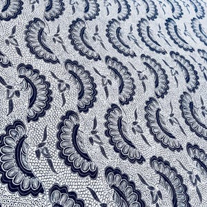 May include: A textile fabric featuring a repeating pattern of dark blue fan-shaped floral motifs on a white background. The design includes intricate, curved petal shapes and delicate leaf elements, all set against a fine, dotted texture.
