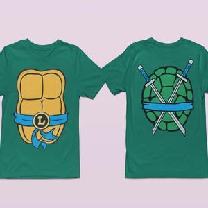 May include: Two green t-shirts with a Teenage Mutant Ninja Turtles theme. One shirt features a yellow and orange turtle shell with a blue bandana and the letter "L". The other shirt features a green turtle shell with two crossed swords and a blue bandana.