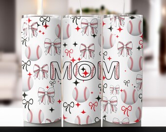 Puede incluir: Un vaso blanco con un patrón de béisbol y lazo. La palabra "MOM" está escrita en negro con un diseño de costura roja.