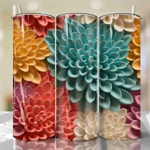 May include: Three stainless steel tumblers with a floral design. The tumblers feature a close-up of colorful paper flowers in shades of pink, yellow, blue, and white.