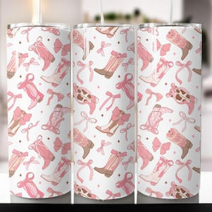 May include: A white tumbler with a pink and brown cowboy boot and bow pattern.