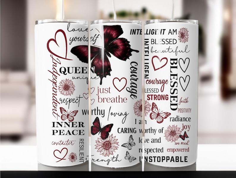 May include: White tumbler with a butterfly and floral design. The tumbler features inspirational words like "Queen", "Blessed", and "Unstoppable" in a mix of fonts and colors. The design includes hearts and butterflies.
