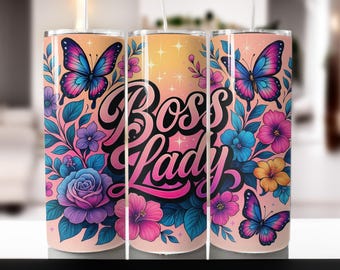 May include: A tumbler with a floral and butterfly design. The tumbler features the words "Boss Lady" in a cursive font. The design includes pink, purple, blue, and yellow flowers, along with butterflies in shades of pink and blue.