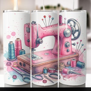 Może przedstawiać: Biały kubek z akwarelową ilustracją różowej maszyny do szycia, szpulek nici, nożyczek i szpilek. Projekt zawiera niebieskie i różowe plamy akwareli. Kreatywny design dla entuzjastów szycia.