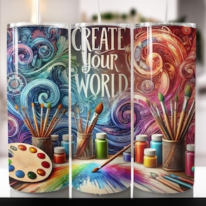 Op de afbeelding: Een kleurrijke beker met de tekst "CREATE YOUR WORLD". Het ontwerp bevat penselen, paletten en verfpotten. De achtergrond heeft wervelende patronen in blauwe, groene, rode en oranje tinten.