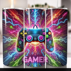 May include: A colorful gamer-themed tumbler with a neon pink, green, and blue design. The tumbler features a video game controller with a neon pink, green, and blue design. The word "GAMER" is printed in neon pink letters on the tumbler.