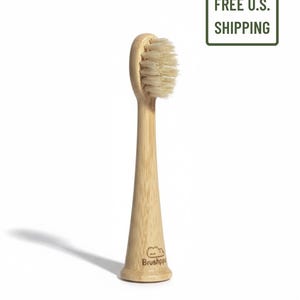 May include: A bamboo toothbrush with a light brown handle and a head of soft, light-colored bristles. The handle has a flared base with the brand name "Brushhopp" printed on it. The image also includes a green rectangle with the text "4 PACK" and "FREE U.S. SHIPPING".