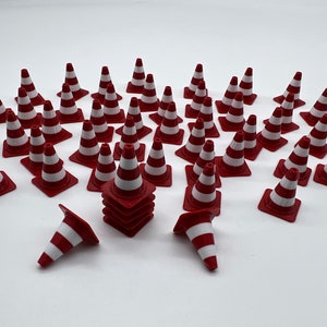 Könnte beinhalten: Eine Sammlung von 25 roten und weißen Verkehrskegeln, einige übereinander gestapelt. Die Kegel sind aus Kunststoff und haben eine reflektierende Oberfläche.