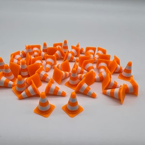 Könnte beinhalten: Eine Gruppe von 25 Miniatur-Verkehrskegeln in Orange und Weiß. Die Kegel sind aus Kunststoff und etwa 2,5 cm hoch.