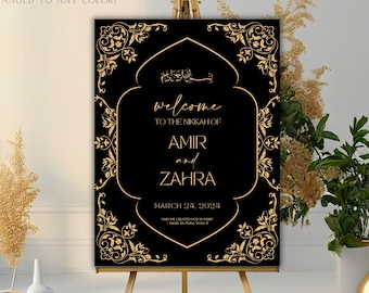 May include: A black welcome sign with gold calligraphy and ornate borders. The sign reads "Welcome to the Nikkah of Amir and Zahra, March 24, 2024".