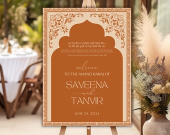 May include: A welcome sign for a wedding ceremony with an ornate border in orange and gold. The sign reads "Welcome to the Anand Karaj of Saveena and Tanvir June 24, 2024".