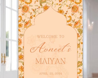 May include: A welcome sign with a peach background and floral border. The sign features a peach archway with the text "Welcome to Avneet's Maiyan April 22, 2024".