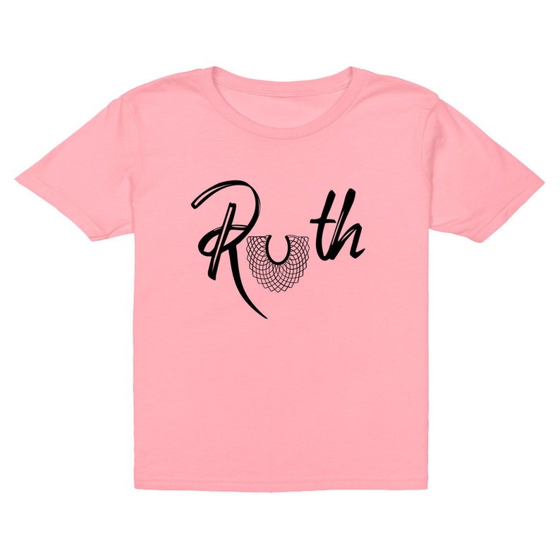 May include: Pink youth-sized t-shirt with black text that reads "Ruth" with a stylized black collar design.
