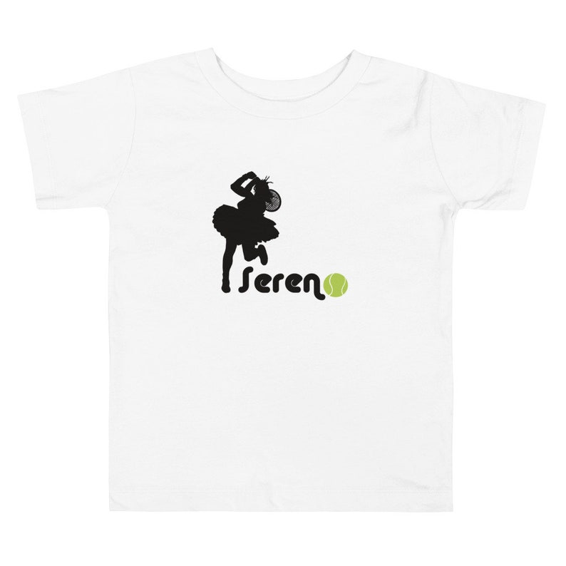 Puede incluir: Camiseta blanca con una silueta negra de una mujer jugando al tenis y la palabra "sereno" con una pelota de tenis verde.