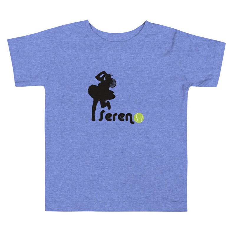 Puede incluir: Una camiseta azul claro con una silueta negra de una jugadora de tenis y la palabra "sereno" con una pelota de tenis amarilla.