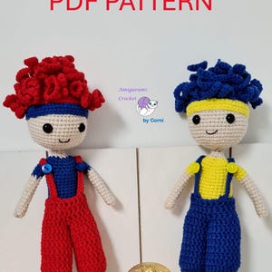 Peut inclure: Patron PDF pour crocheter deux poupées amigurumi. Une poupée a les cheveux rouges et une salopette rouge, l'autre a les cheveux bleus et une salopette bleue. Les deux poupées ont des bandeaux jaunes et portent des chaussures bleues.