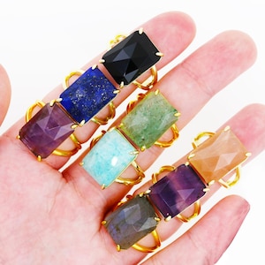 Puede incluir: Un conjunto de ocho anillos de oro con diferentes engastes de piedras preciosas. Las piedras preciosas son amatista, aguamarina, aventurina, ónix negro, labradorita, lapislázuli, cuarzo rosa y piedra de sol.