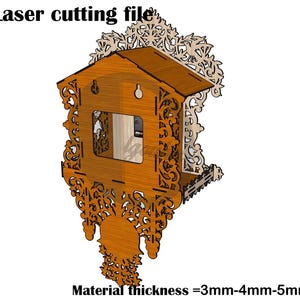 Op de afbeelding: Een digitaal lasersnijbestand voor een houten koekoeksklok met ingewikkeld krulwerk, een centrale vierkante opening en een puntdak. De tekst luidt Laser cutting file en Material thickness = 3mm-4mm-5mm, met iconen voor SVG, AI, PDF, CDR, PS en DWG.