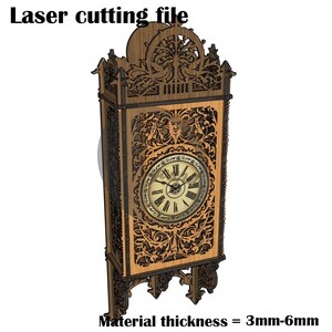 May include: A laser cutting file for a wooden wall clock with intricate, dark brown, laser-cut filigree patterns surrounding a central circular clock face with Roman numerals. The text reads Laser cutting file and Material thickness = 3mm-6mm.