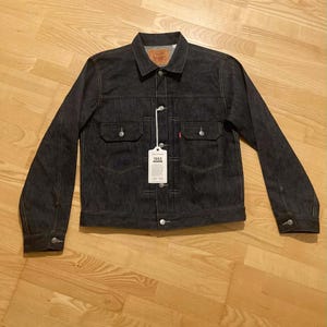 Op de afbeelding: Set van drie keramische mokken met een gespikkelde, matte afwerking. De mokken zijn in crème, lichtgrijs en donkergrijs. Elke mok heeft een eenvoudig, minimalistisch ontwerp.