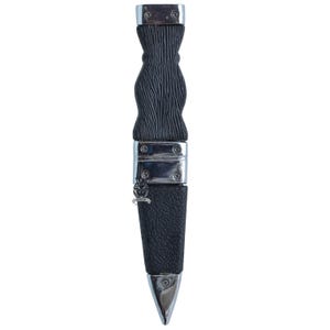 May include: A black and silver dagger with a textured handle and a leather sheath. The handle has a unique, carved design. The sheath is made of black leather and is accented with silver metal. The dagger's blade is silver and pointed.