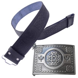 Op de afbeelding: Een zwarte leren riem met Keltische knoopwerk en een decoratieve gesp. De gesp is zilverkleurig met een centraal Keltisch knoopontwerp, omgeven door bloemen- en distelmotieven. De riem heeft een blauwe binnenkant.