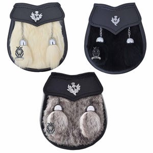 May include: Three sporrans with black leather tops and fur fronts. One is cream-colored, one is black, and the third is gray. Each has a silver emblem and tassels. The bottom of each sporran has a lion emblem and the words "Lion of Scotland".