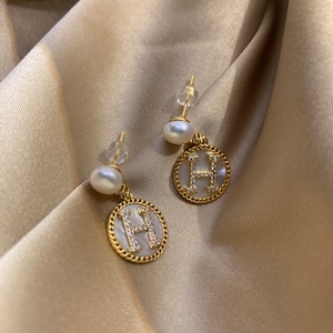 Pendientes de perla con la letra "H" en nácar. Joyas iniciales con nombre, letra y perla.