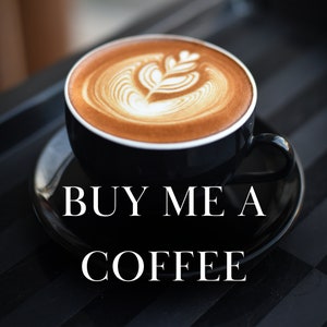 May include: A black coffee mug with a white latte art design. The mug is on a black and white checkered surface. The text "BUY ME A COFFEE" is written in white letters on the surface.