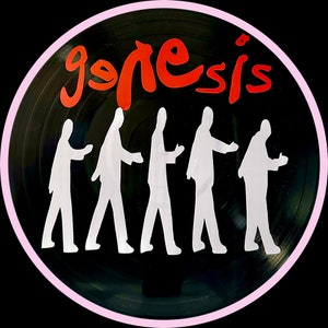 May include: A round sticker featuring a black vinyl record design with a pink border. The word "genesis" is written in red script above a row of white silhouettes of people walking.