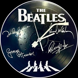 Beatles Themed Wall Clock.  Minute Hand Looks Like The Arm From A Record Player.  Not On An Actual Vinyl Record.