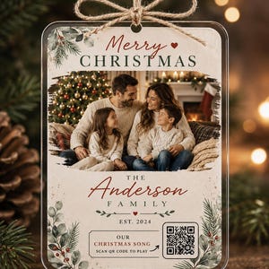 Może przedstawiać: Prostokątna akrylowa ozdoba świąteczna ze zdjęciem rodziny, napisem Merry Christmas, The Anderson Family, Est. 2024 oraz Our Christmas Song z kodem QR. Wzór zawiera zielone gałązki sosny i czerwone jagody jako elementy dekoracyjne.