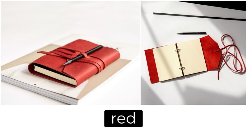 May include: A red leather journal with a pen resting on top, secured by a wraparound strap. The journal is on a stack of paper. The image also shows an open red journal with cream-colored pages and a pen.