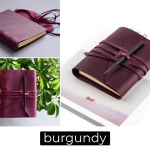 May include: Burgundy leather journal with a wrap-around closure and a pencil holder. The journal has a gold-colored edge and a matching burgundy strap. The word "burgundy" is displayed in a black rectangle at the bottom of the image.