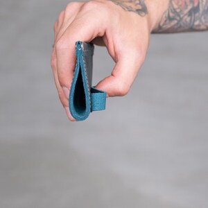 May include: A folded leather wallet with a blue suede exterior and a stitched seam down the center.