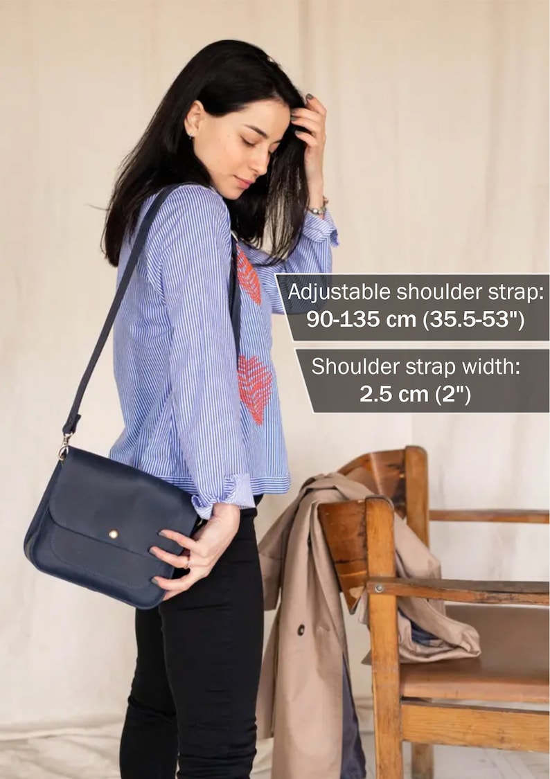 Pu&ograve; includere: Una borsa a tracolla in pelle blu scuro con chiusura a bottone dorato. La borsa ha una tracolla regolabile che misura da 90 a 135 cm di lunghezza e 2,5 cm di larghezza.