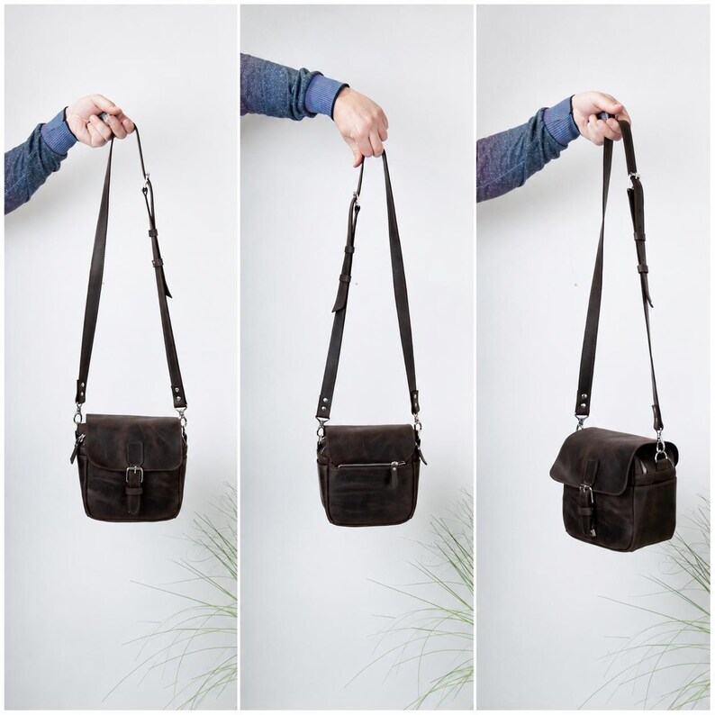 May include: A dark brown leather crossbody bag featuring a fold-over flap with a metal buckle closure, an adjustable shoulder strap, and a zippered pocket on the exterior. The bag is shown from the front, back, and side angles to display its design.