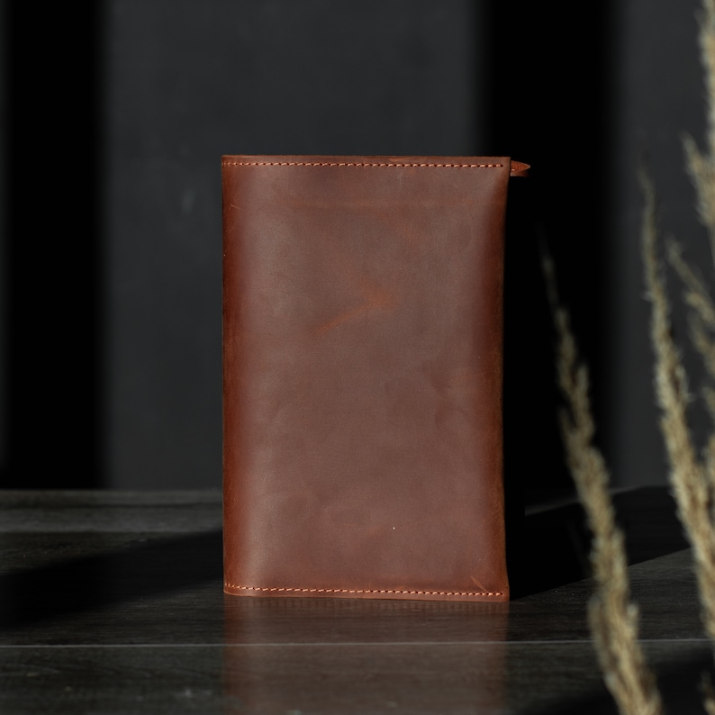 May include: A brown leather wallet with a stitched edge.
